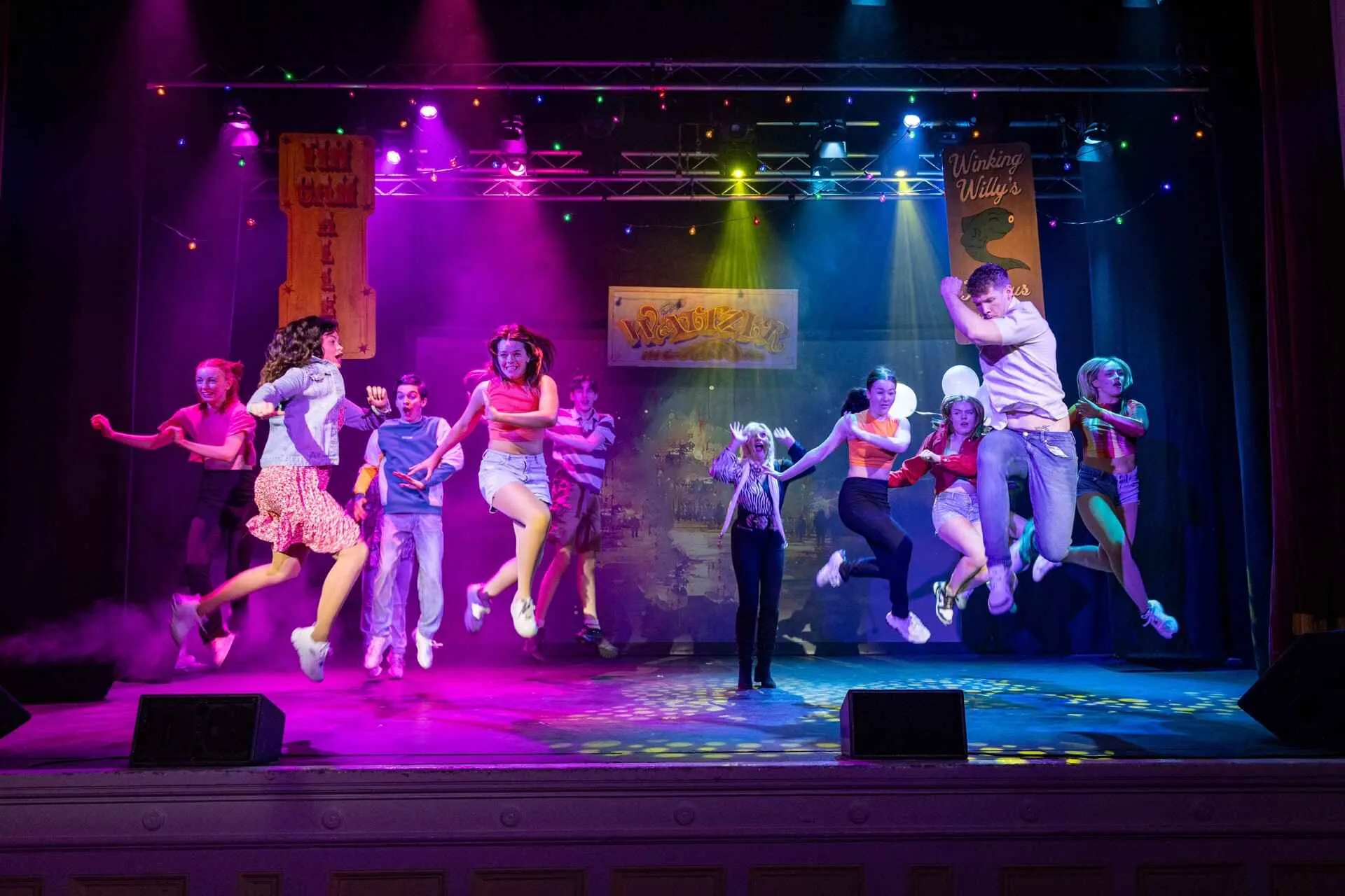 dancers on a stage under multicoloured bright lights